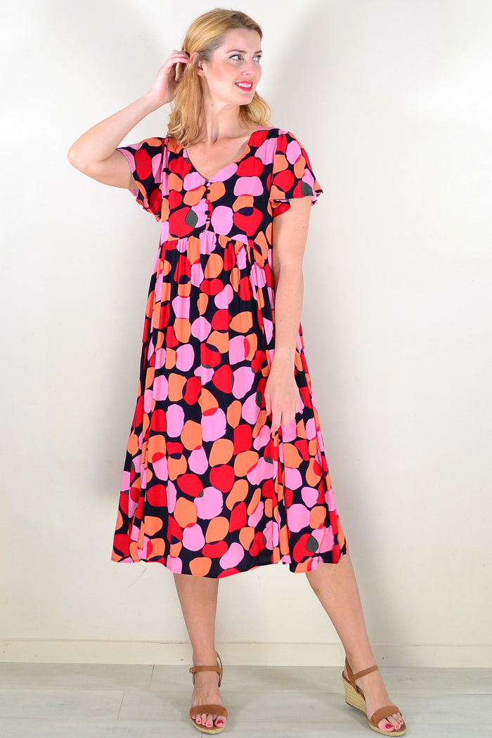 Pink-orange spotted tunic dress from Hourglass with a relaxed fit, displayed on a mannequin against a neutral background.