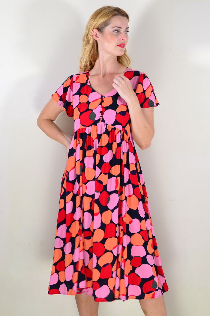 Pink-orange spotted tunic dress by Hourglass featuring a relaxed fit and stylish design, shown on a model.