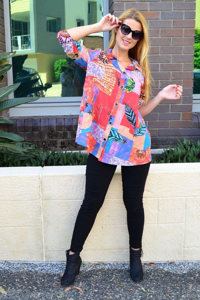 Ruby Rain quilted pocket high collar tunic shirt hanging on a hanger, showcasing its quilted fabric and stylish high collar design.