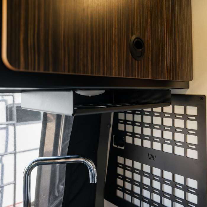 Revel undercabinet shelf mounted below overhead cabinet in van kitchen interior.
