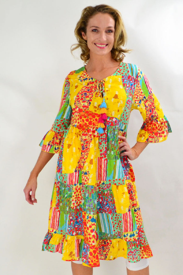 Wishstone Sandy Beach tiered tunic dress displayed with flowing fabric and beach-inspired design on a neutral background.