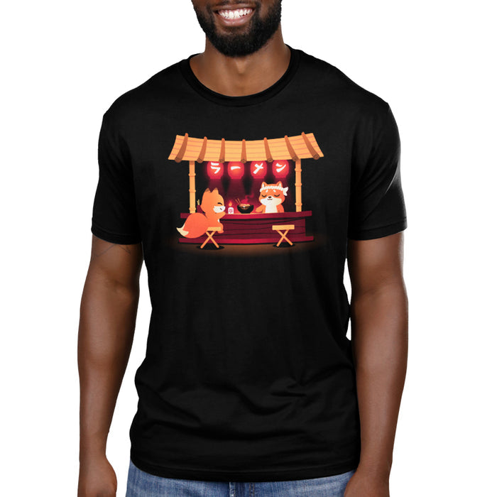 Premium Cotton T-shirt_TeeTurtle Shiba's Ramen Stall black t-shirt featuring an orange fox sitting being served by an orange shiba inu at a food stall. The stall is decorated with red lanterns and a bowl of steaming noodles is being served.