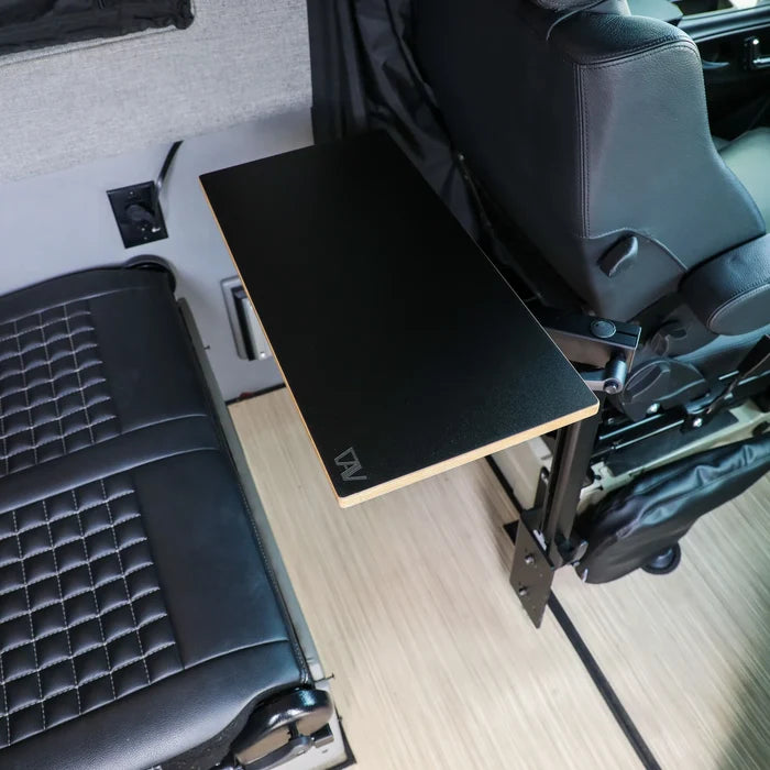 Small universal tabletop mounted beside van seat with wood floor and black leather upholstery