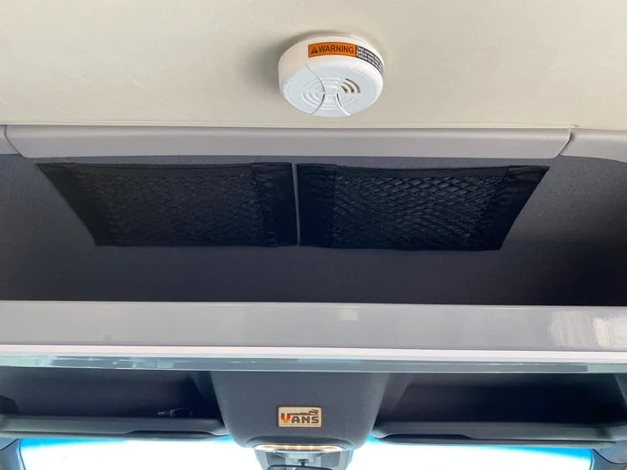 Overhead dual mesh storage net inside a van, mounted above the drivers area.