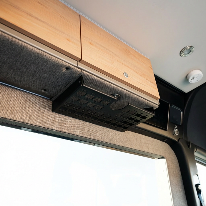 Storyteller undercabinet shelf installed on the driver side of the van interior ceiling area.