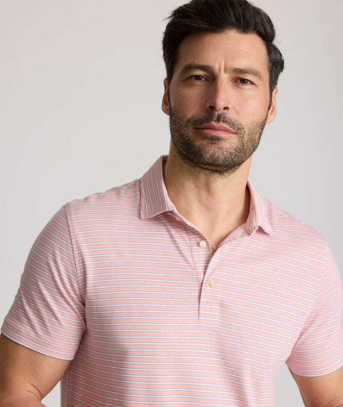 Model is wearing UNTUCKit Fernandez Striped Performance Polo in Pink Quartz.
