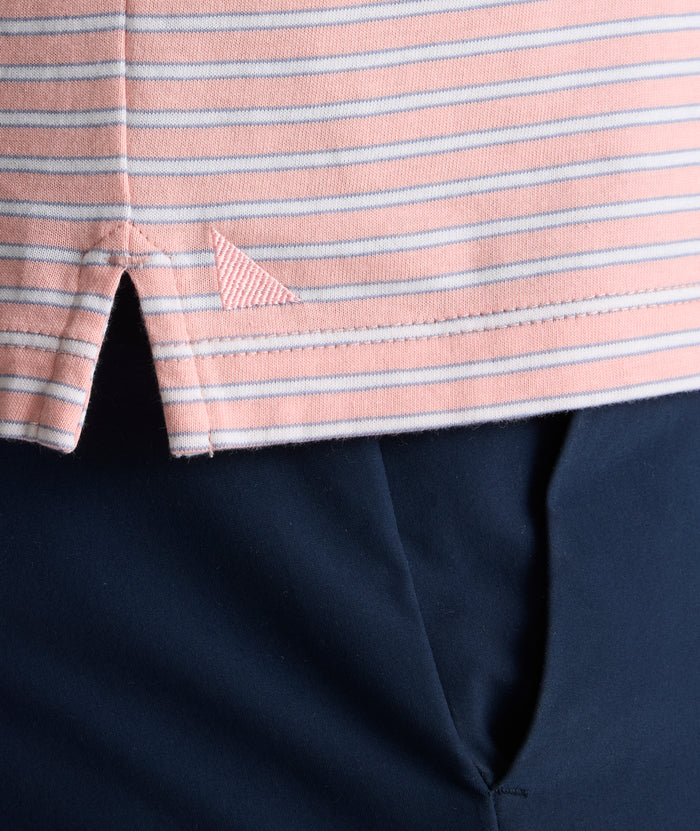 Model is wearing UNTUCKit Fernandez Striped Performance Polo in Pink Quartz.