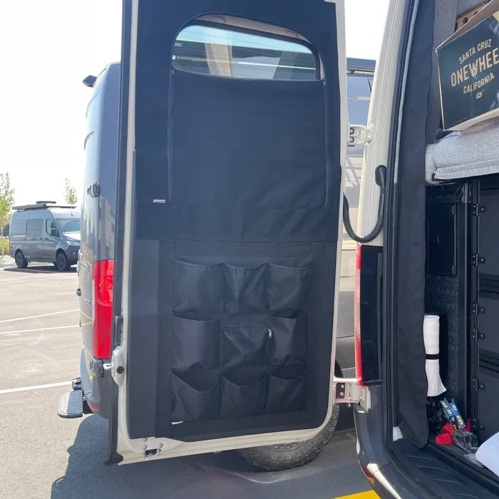 DOORGANIZER storage panel mounted on rear van door with mesh pockets and zippered pouch.