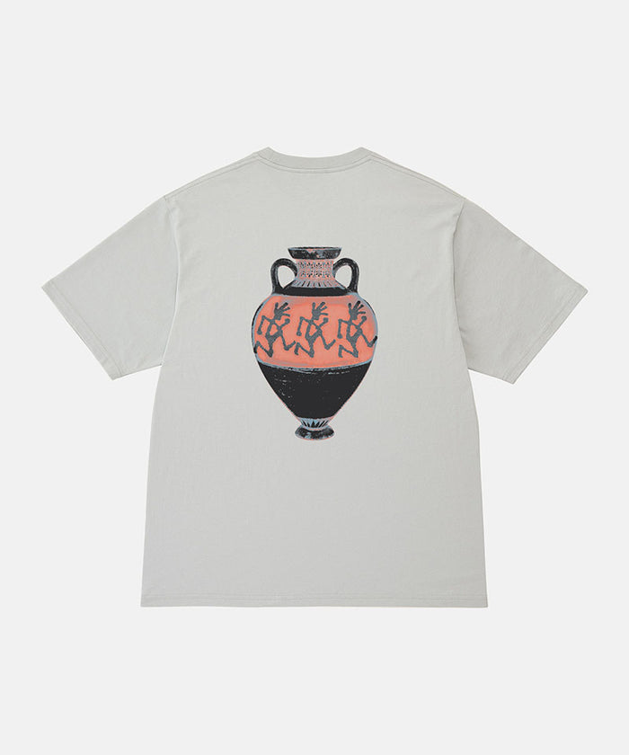 Back view of a Gramicci mist colored Vase Tee with a graphic against a light-tone background.